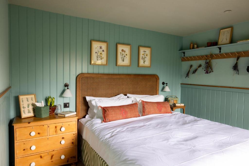 a bedroom with a bed and a wooden dresser at The Merry Harriers Pub in Hambledon