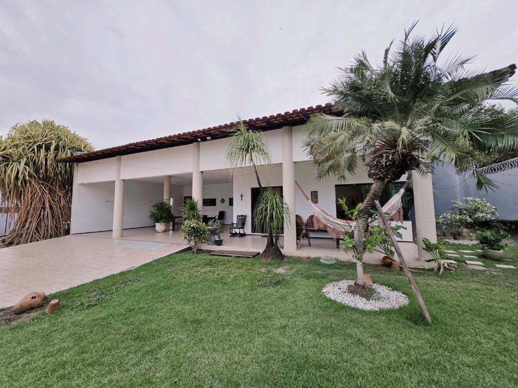 a house with palm trees in front of it at Casa de praia in São Luís