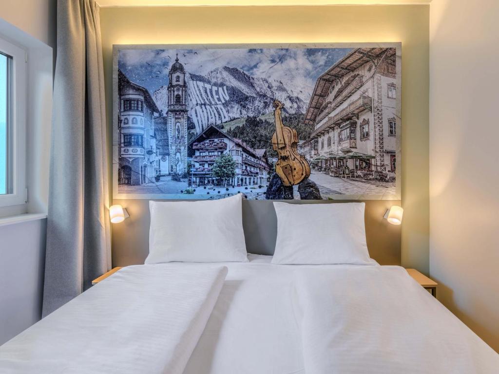 a bedroom with a white bed with a painting on the wall at B&B HOTEL Mittenwald in Mittenwald