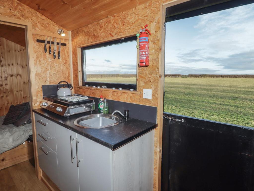 a kitchen in a tiny house with a sink and a window at Rhosgranog Shepherds Hut in Haverfordwest