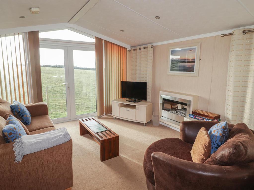 a living room with two couches and a television at Rhosgranog Caravan in Haverfordwest