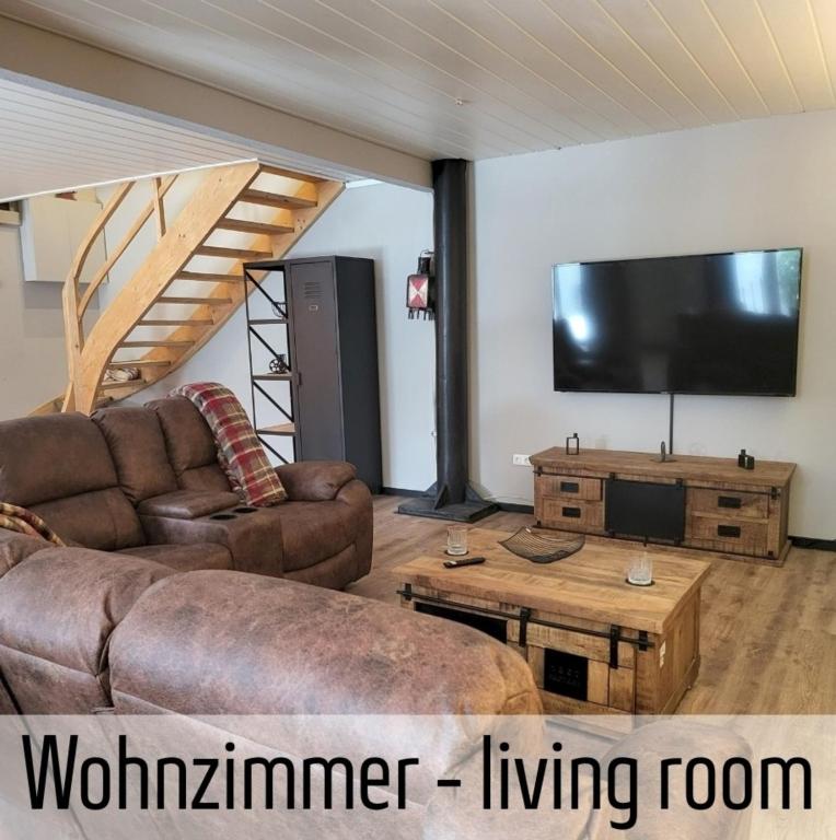a living room with a couch and a flat screen tv at Lokschuppen - Backstein-Loft in Bad Oeynhausen