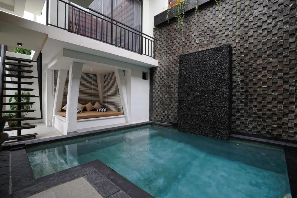 a swimming pool in the middle of a house at Cleo Villa Padma Legian in Seminyak
