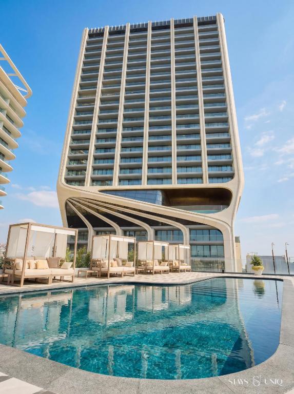 a building with a swimming pool in front of a building at Mercury Suites Apartment with Pool Access in St Julians in St. Julianʼs