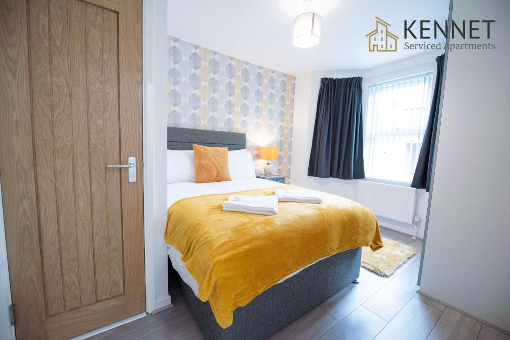 a bedroom with a bed with a yellow blanket on it at Franklin Lodge in Reading