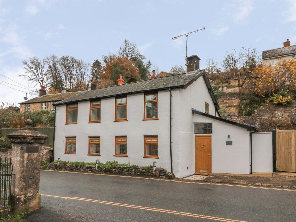 a white house on the side of a street at The Old Workshop in Dulverton