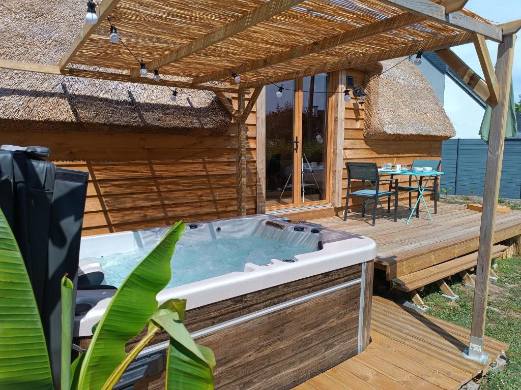 a hot tub on the deck of a house at Tiny Chaumière - Escapade Romantique - Chaumière et Jacuzzi Privatif proche Pont-Aven in Riec-sur-Bélon