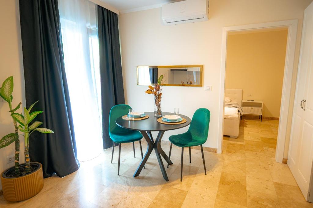 a dining room with a table and green chairs at RMR Luxury Apartaments in Timişoara