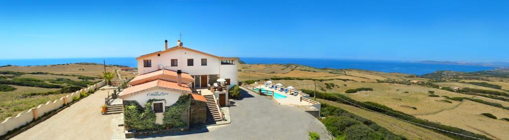 a building on top of a hill next to the ocean at Agriturismo Finagliosu in Palmadula