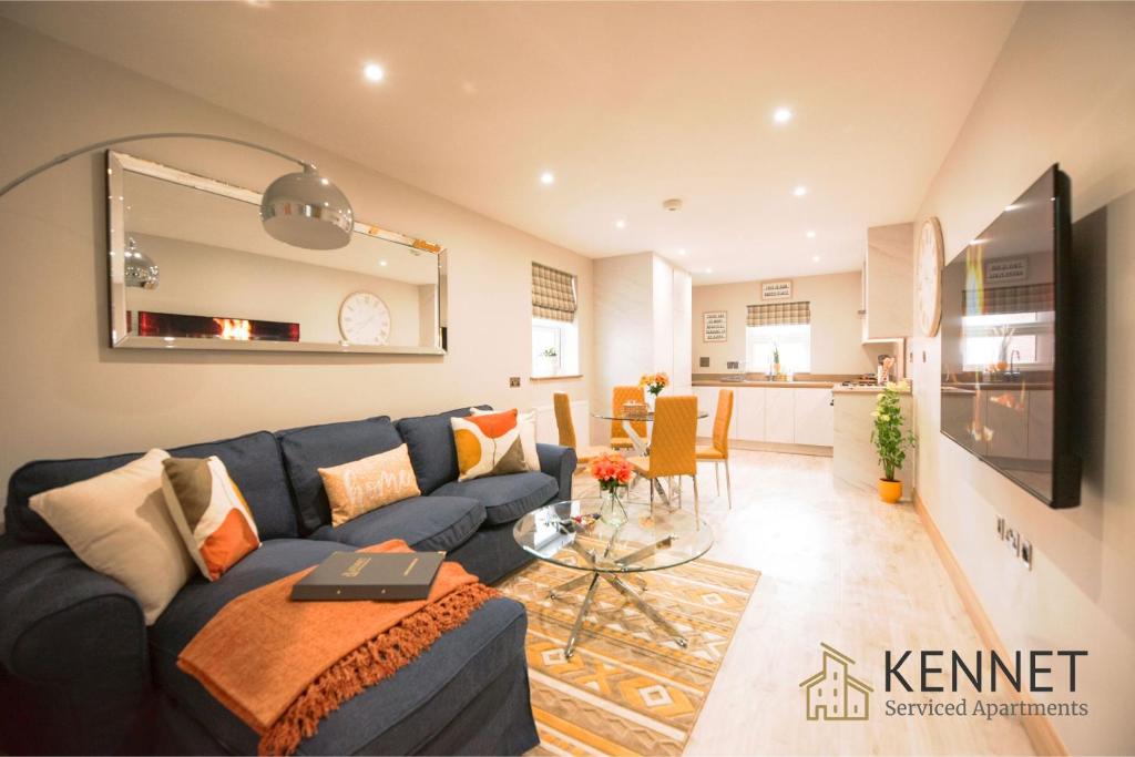 a living room with a blue couch and a kitchen at Elm House in Reading