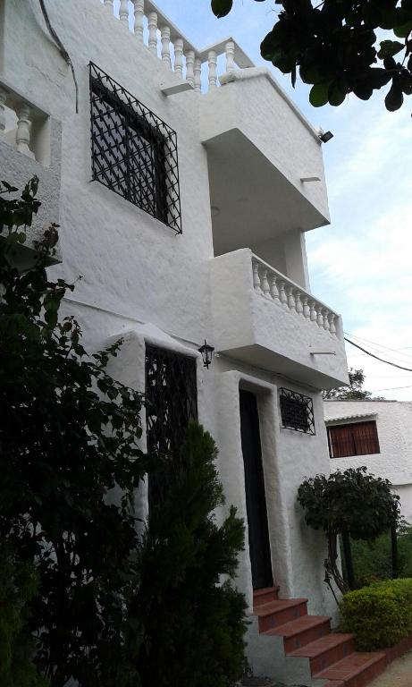 una casa blanca con una escalera delante en Cabaña Familiar La Aldea Doradal, en Gesen