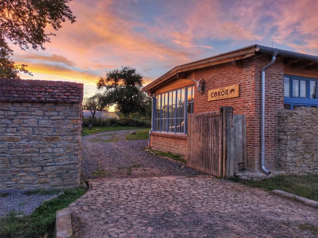 an old brick building with a sign on it at Ferma de Biodiversitate COBOR in Cobor
