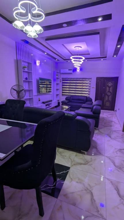 a purple room with couches and a table and chairs at Lux 3bedroom apartment in Okunola