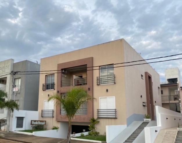 a building with a palm tree in front of it at Punto Termal - Depto 8 in Federación