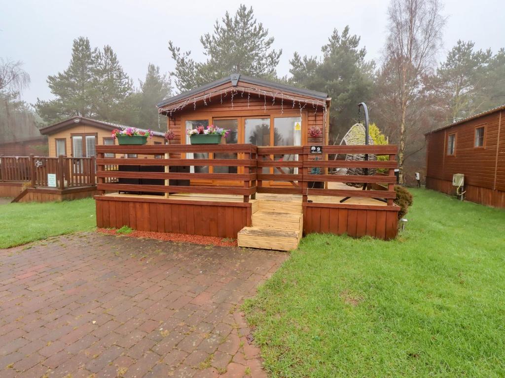 a wooden cabin in a yard with a house at Chloe's Cabin in Morpeth
