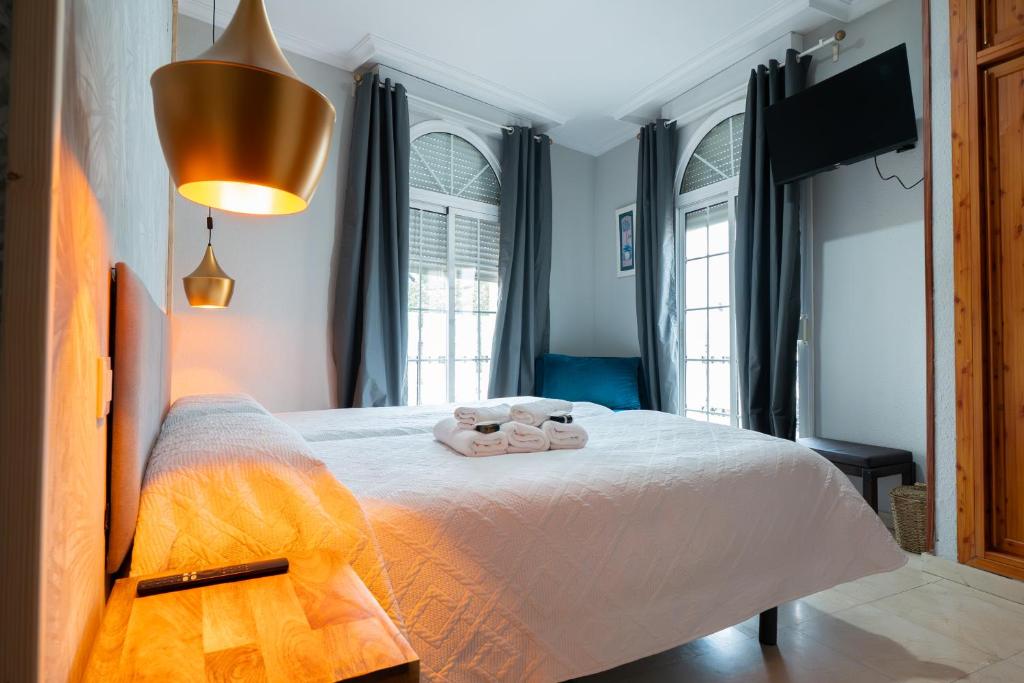 a bedroom with a bed with two towels on it at Hostal La Muralla in Seville