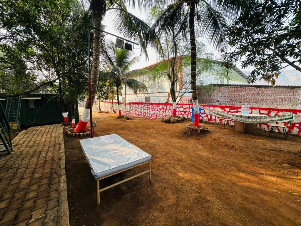 a park with a table and benches and palm trees at TOMS' Cabin Farmhouse in Chauk