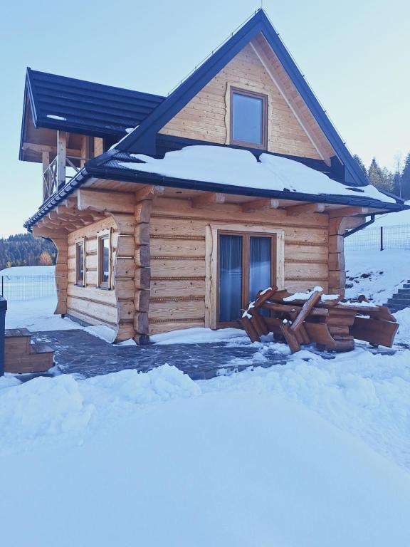 a log cabin with snow on the ground at Góralska Przystań in Nowa Wieś
