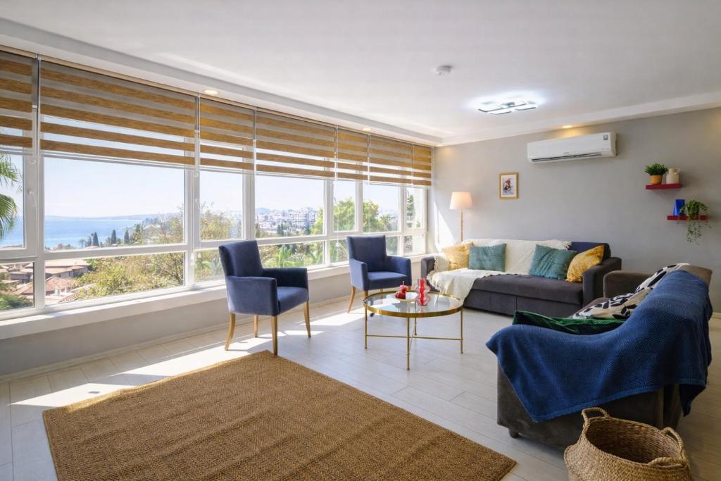 a living room with a couch and some windows at MaxiHomes Hadrian in Antalya