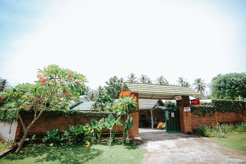 a brick house with a green door in a yard at Tiffany Garden in Mangsit