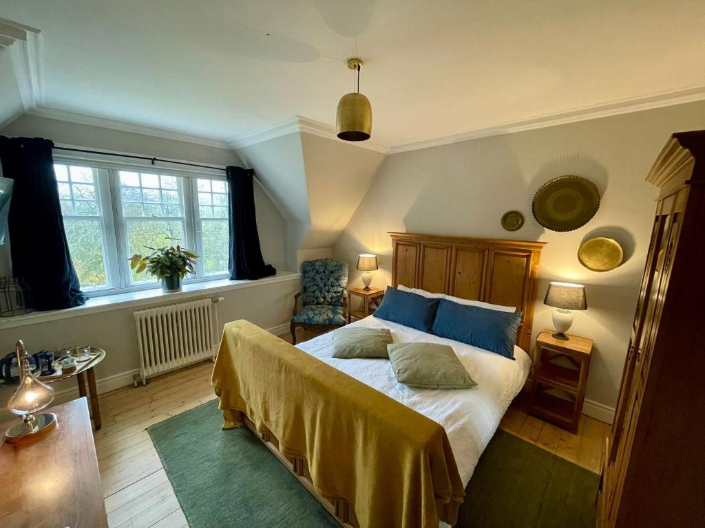 a bedroom with a bed with blue pillows on it at Room 3, Wedale House in Stow