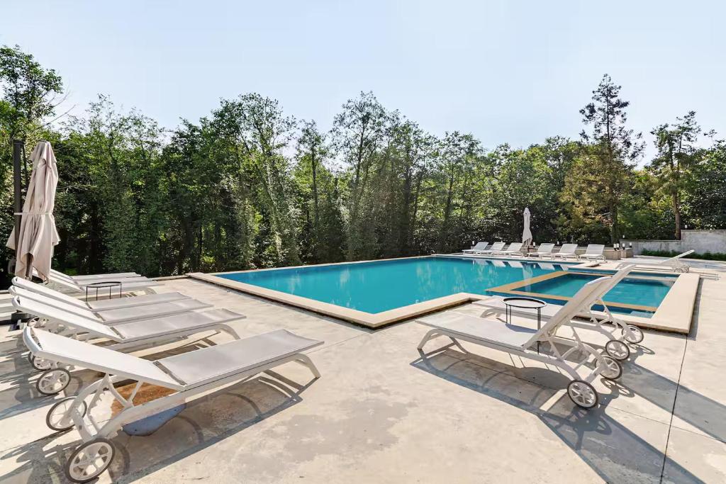 a swimming pool with lounge chairs and a swimming pool at Gantiadi Holiday - Pool and Houses in Batumi