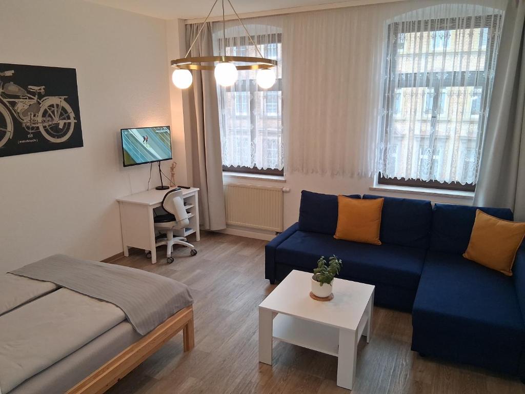 a living room with a blue couch and a table at Geräumige Stadtwohnung mit Balkon in Zwickau
