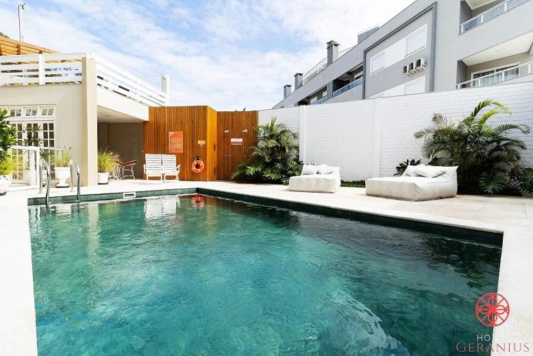 a swimming pool in front of a house at Hotel Geranius Ingleses in Florianópolis