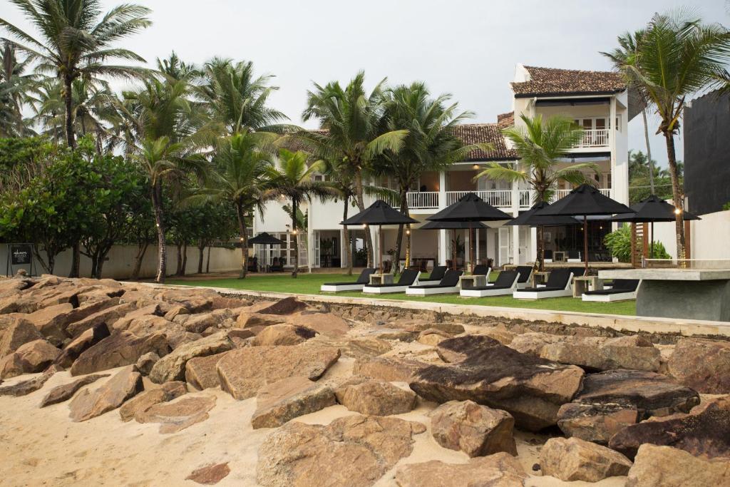 a resort with chairs and umbrellas on the beach at Arabella on Boossa in Galle