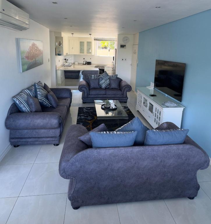 a living room with two couches and a table at Sea Lodge G01 in Durban