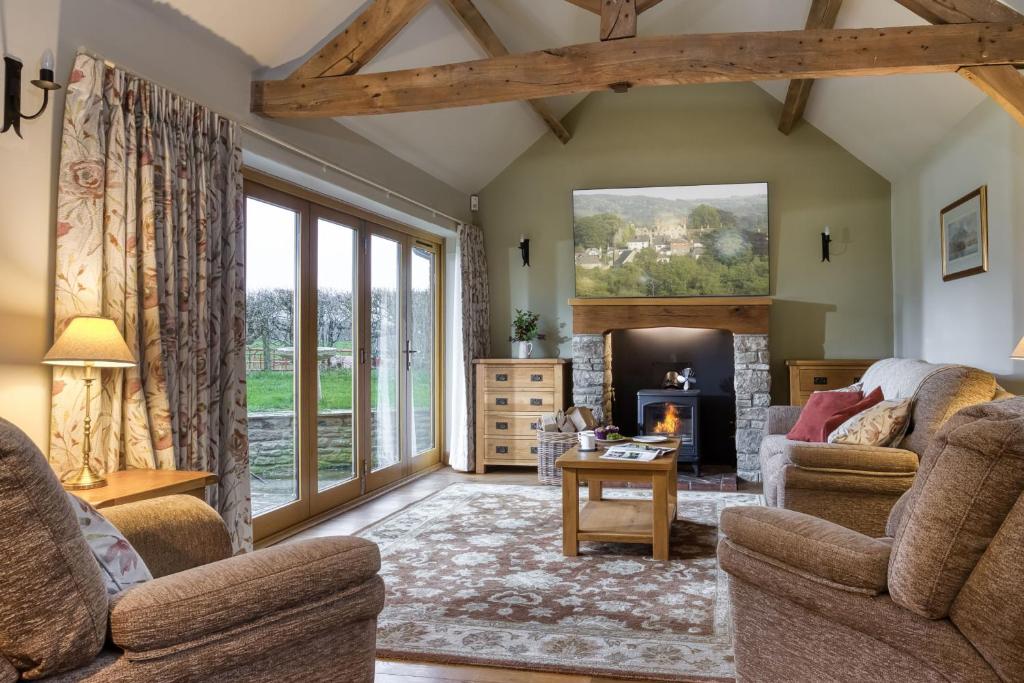 a living room with two chairs and a fireplace at Long Barn in Ludlow