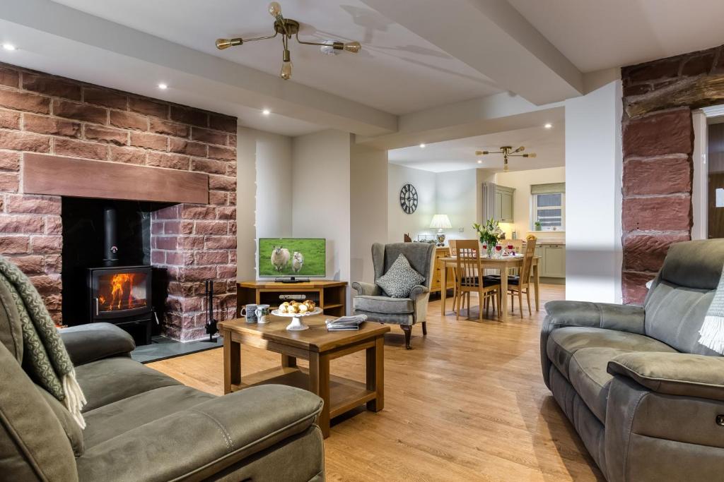 a living room with a couch and a fireplace at Hill Top Farm in Penrith