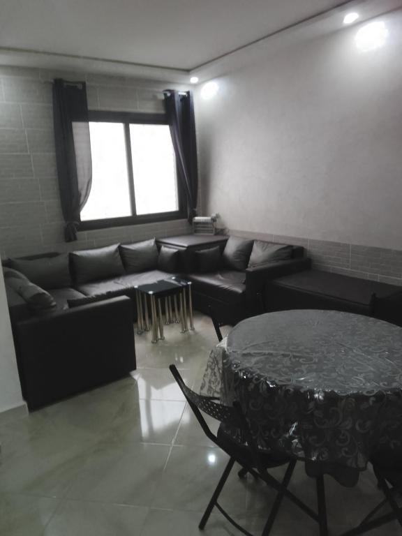 a living room with a table and a couch at Chez Franck in Saïdia