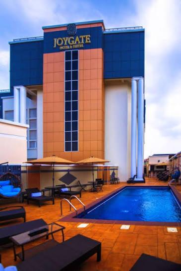 a hotel with a swimming pool in front of a building at Joygate Hotels & Suites in Lagos