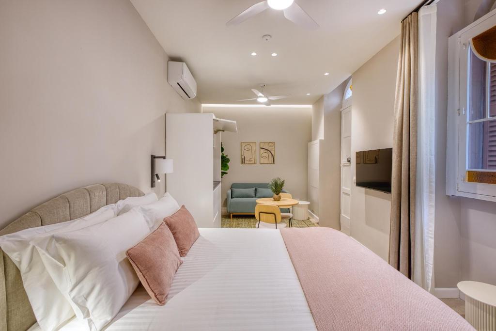 a bedroom with a white bed and a blue chair at NORFOLK Suites in Sliema