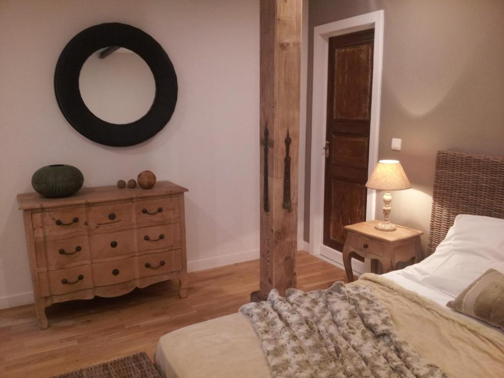 a bedroom with a bed and a mirror and a dresser at Coté Cour Bischwihr Colmar 2 in Bischwihr