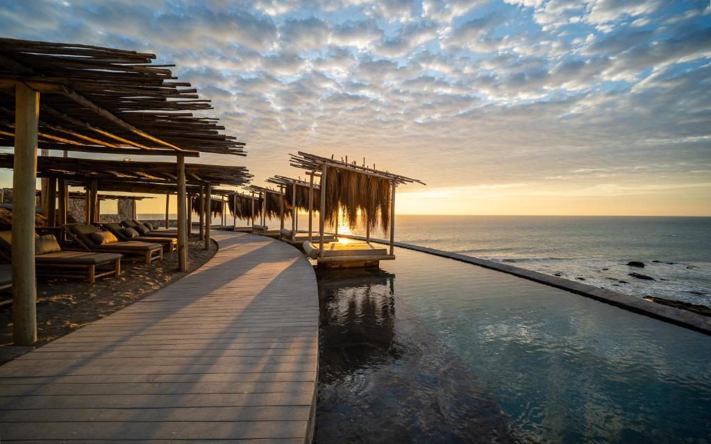 a resort infinity pool with a view of the ocean at Inkaterra Cabo Blanco in Talara
