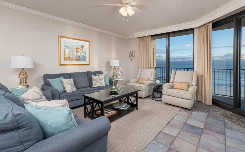 a living room with a blue couch and chairs at Phoenix X 609 condo in Orange Beach