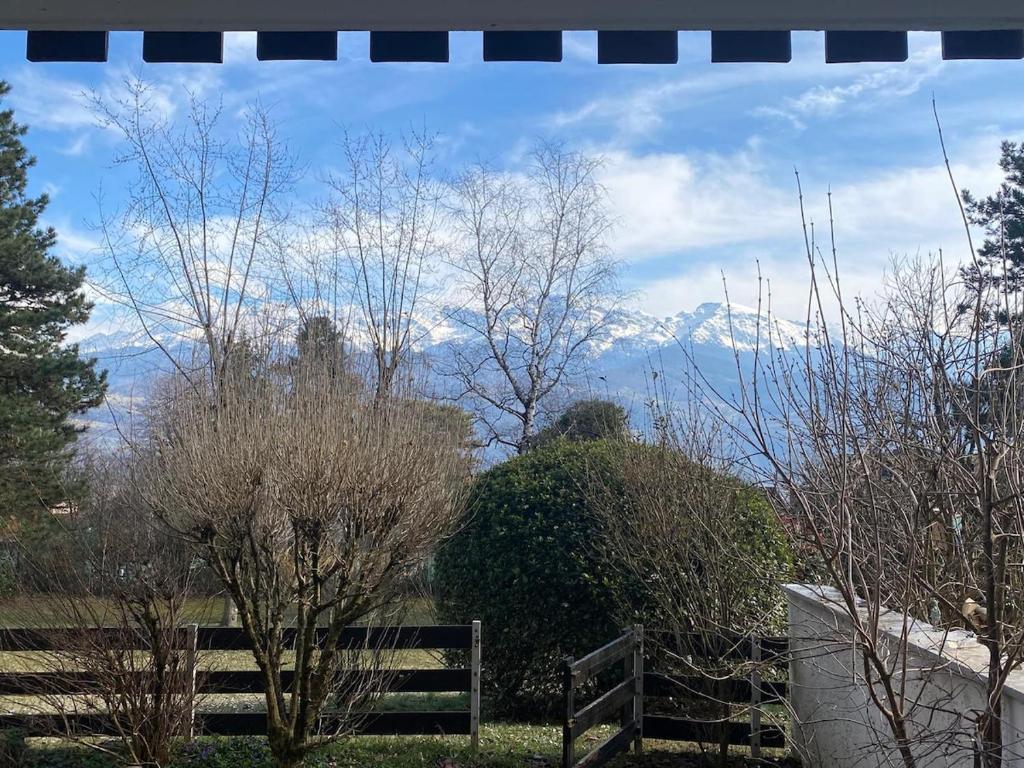 a fence and trees with mountains in the background at Charmant appartement et jardin in Saint-Ismier