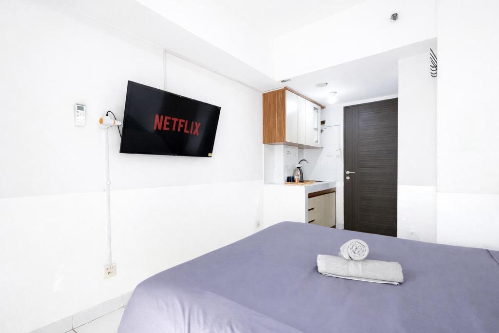 a bedroom with a bed and a tv on the wall at Escotel Amazana in Cileduk 1