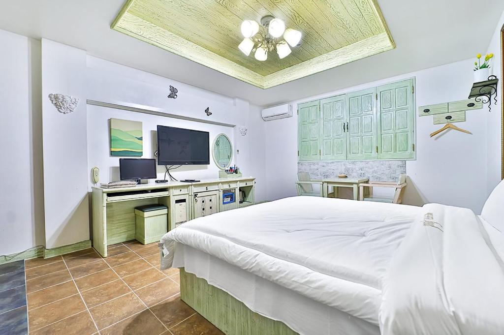 a bedroom with a bed and a desk with a computer at 필사랑무인텔 in Wŏndang-gol
