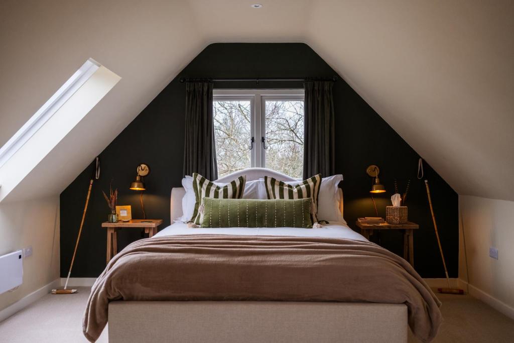 a bedroom with a bed with a black wall at Roost in Heyshott in Midhurst