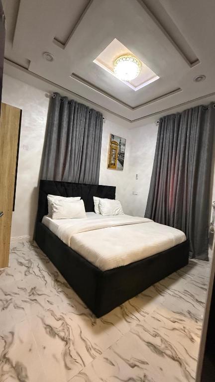 ein Schlafzimmer mit einem großen Bett in einem Zimmer in der Unterkunft ZAPHOMEs in Asaba