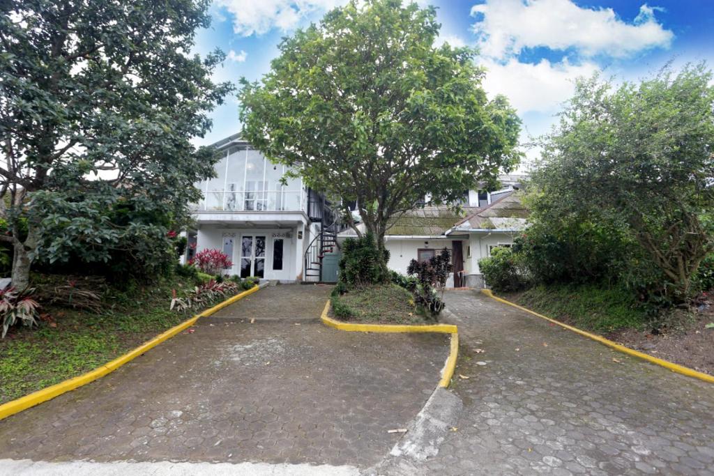 a white house with yellow lines on the driveway at Villa Agape Near Puncak By ARBA in Pasakon 1