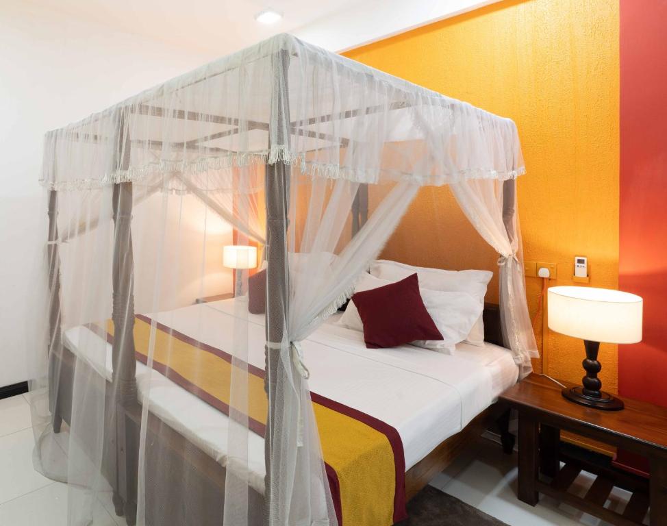 a bedroom with a bed with a canopy at Urban Kandy City Hotel in Kandy