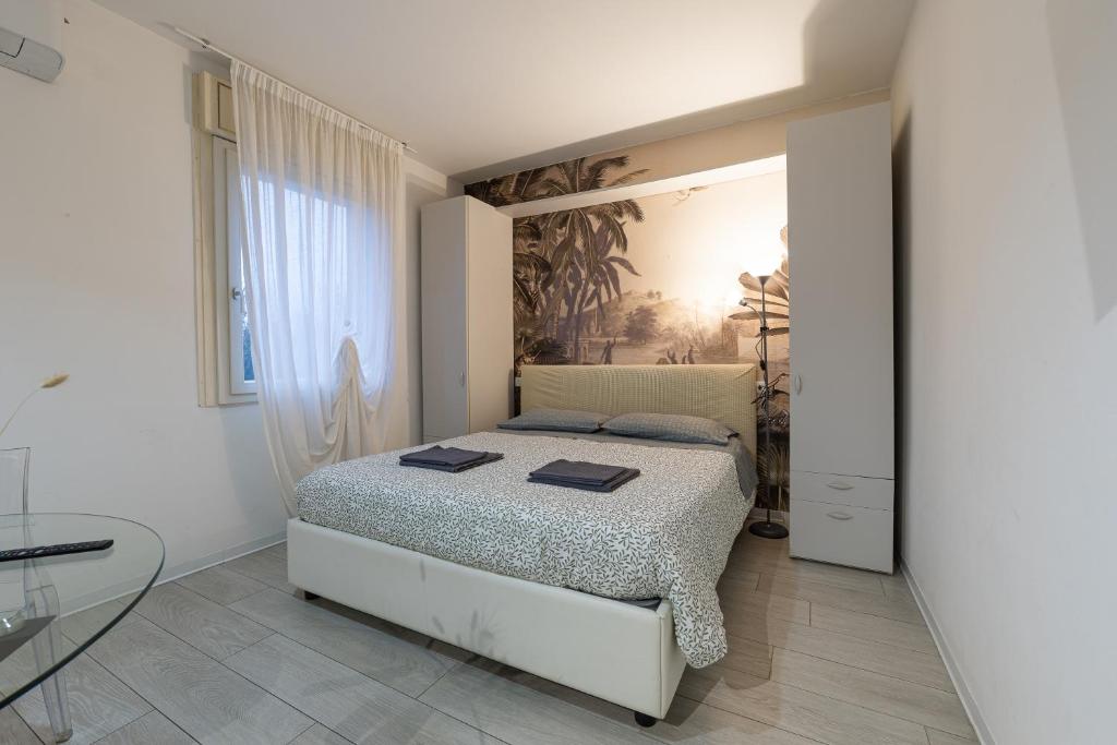 a white bedroom with a bed and a glass table at Casetta in Via Dini in Padova