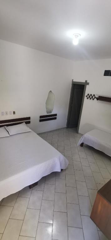 a bedroom with two beds and a tiled floor at Verde & Sal 11 in Ilhéus