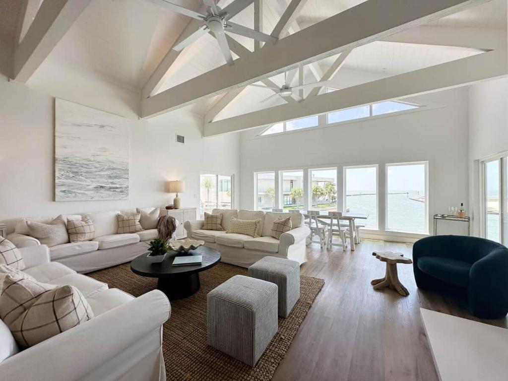 a living room with white furniture and a table at Blue Heron Hideaway in Rockport