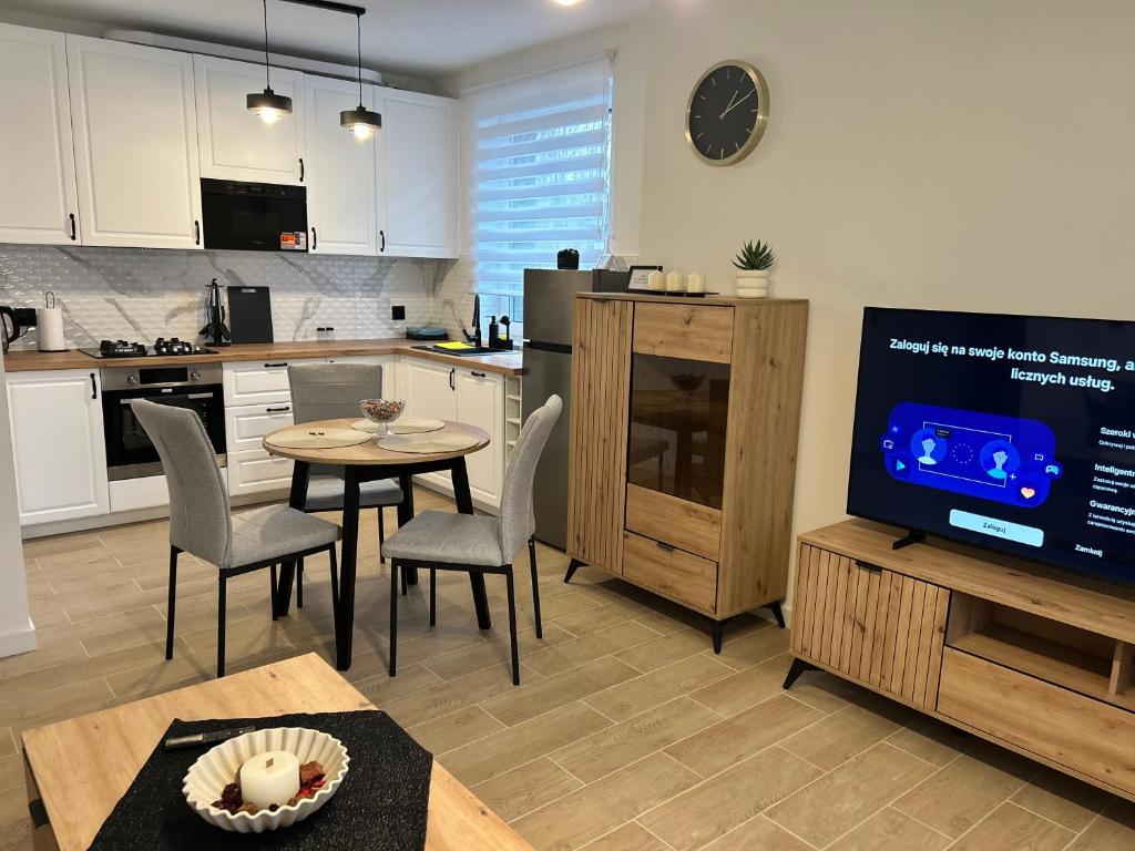 a kitchen with a table and chairs and a tv at Apartament 42 in Sosnowiec