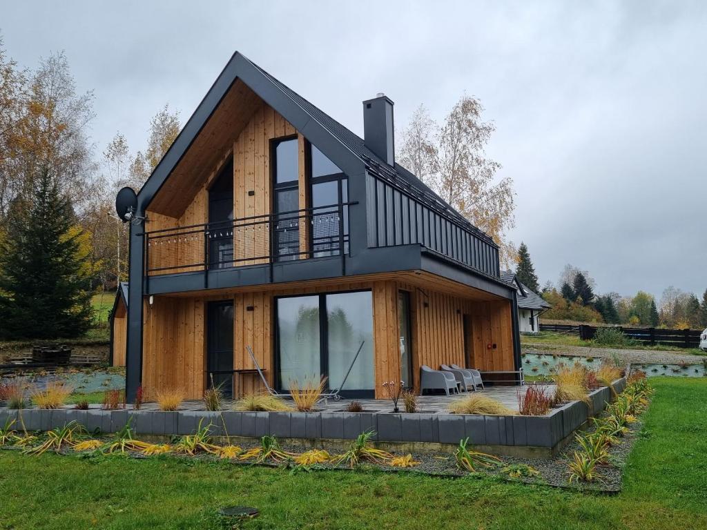 a house with a black roof and windows at Stodoła pod Widetą in Wetlina